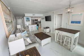 A spacious living area with a kitchen, a dining area, and a bar.
