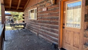 A log cabin with a porch, a door with a glass panel, and a sign reading "Pink Cauld." - Roomy Taylor Canyon Cabin With Private Fishing Access (Almont)