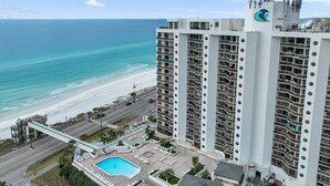 A high-rise hotel with a pool and beach view.