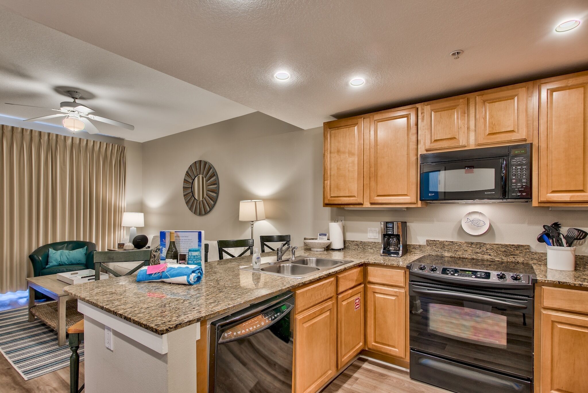 A compact kitchen with wooden cabinets, a built-in microwave, a stove, and a dishwasher.