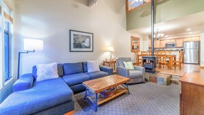 A modern living room with a blue sofa, a wooden coffee table, and a fireplace.