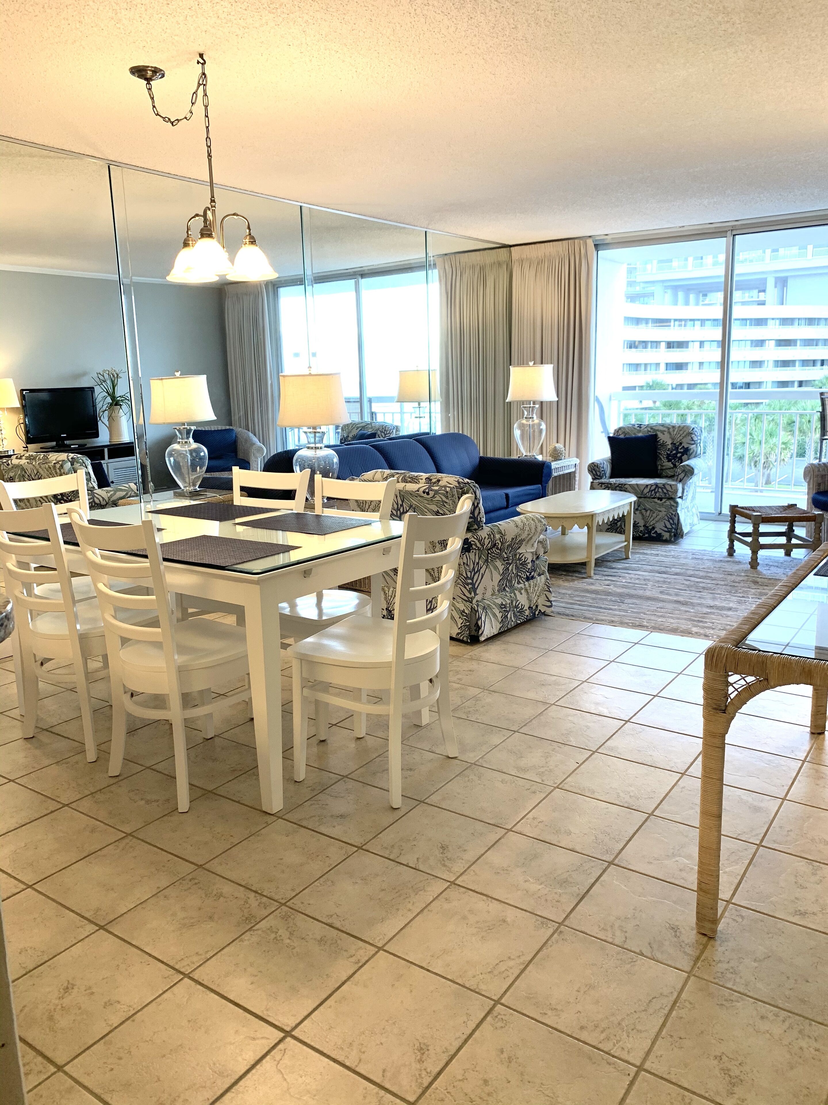 Un salón moderno con comedor, ventanas amplias y vistas a la ciudad.