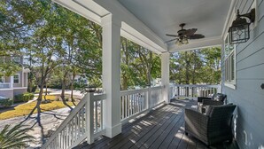A covered porch with a ceiling fan, wicker furniture, and a view of the neighborhood. - 13 Moonshell, Close to Beach, Pool, Big Backyard, Free Golf, Dogs Welcome (Hilton Head)