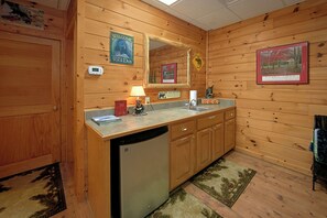 A wooden cabin-style bathroom with a sink, mirror, and a toilet.