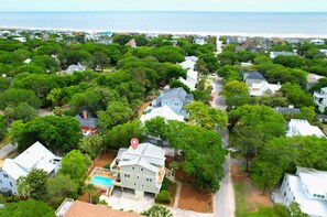 A residential area with houses, a swimming pool, and a view of the ocean.
