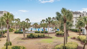 A resort with a swimming pool, palm trees, and a clear sky. - Shorewood 234-Freshly Updated in 2025 3BR Oceanview Near Shops & Restaurants (Hilton Head Island)