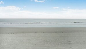 A beach with a wide sandy shore and calm ocean waves. - Shorewood 234-Freshly Updated in 2025 3BR Oceanview Near Shops & Restaurants (Hilton Head Island)