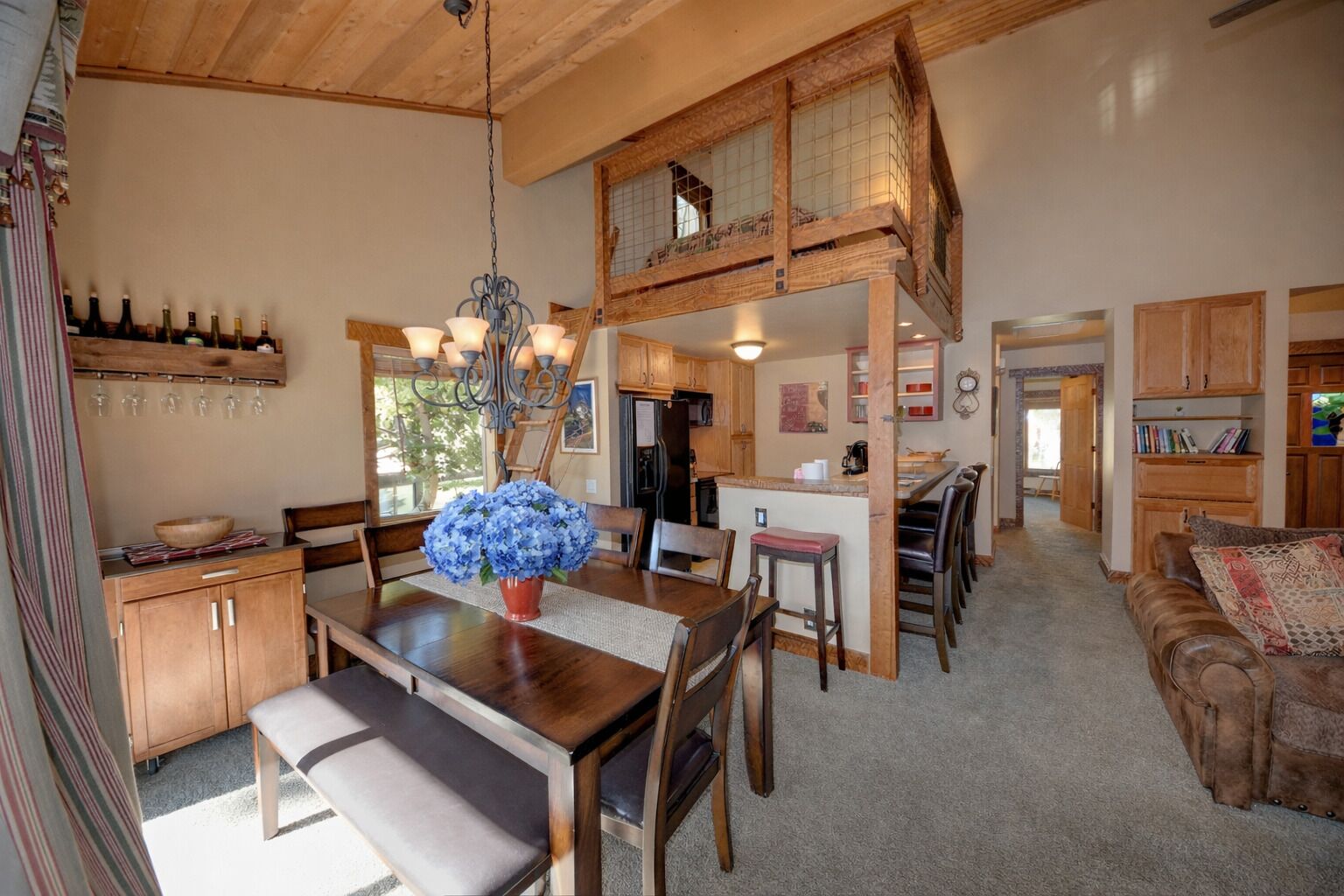 A spacious living area with a dining table, wooden furniture, and a cozy seating area.