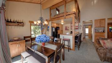 A spacious living area with a dining table, wooden furniture, and a cozy seating area.