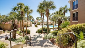 Ein Resort mit Pool, Palmen und einer Treppe zum Poolbereich.