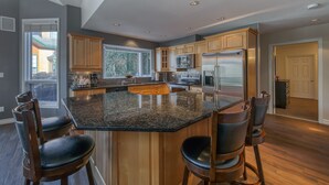 A modern kitchen with granite countertops, stainless steel appliances, and wooden cabinets.