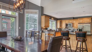 A modern kitchen with wooden cabinets, stainless steel appliances, and a large island.