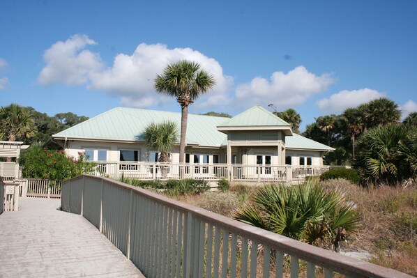 A large, single-story building with a green roof and a covered walkway leading to it.