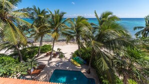 A beach view with palm trees, a swimming pool, and lounge chairs. - Beautiful Hacienda style villa located on white sandy beach, pool, AC, WiFi! (South Akumal)