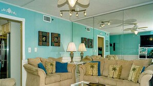 A living room with two beige sofas, a coffee table, and a TV.