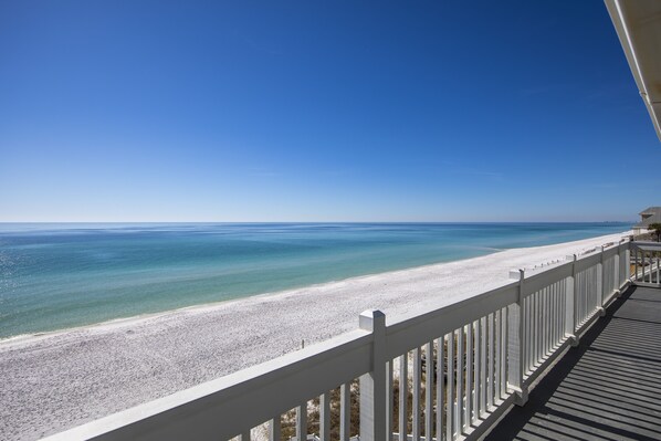 A beach view from a balcony with a white railing and a wooden deck. - Gulf Front, 3rd Level Condo, Elevator, Near Shops and Restaurants- 30A (Santa Rosa Beach)