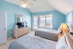 A bedroom with two beds, a dresser, a ceiling fan, and a window with blinds.