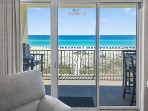 A balcony with a view of the beach and ocean, featuring a chair and a table. - Summer Place 405 - Beautifully Renovated 3Br Beachfront Condo (Fort Walton Beach)