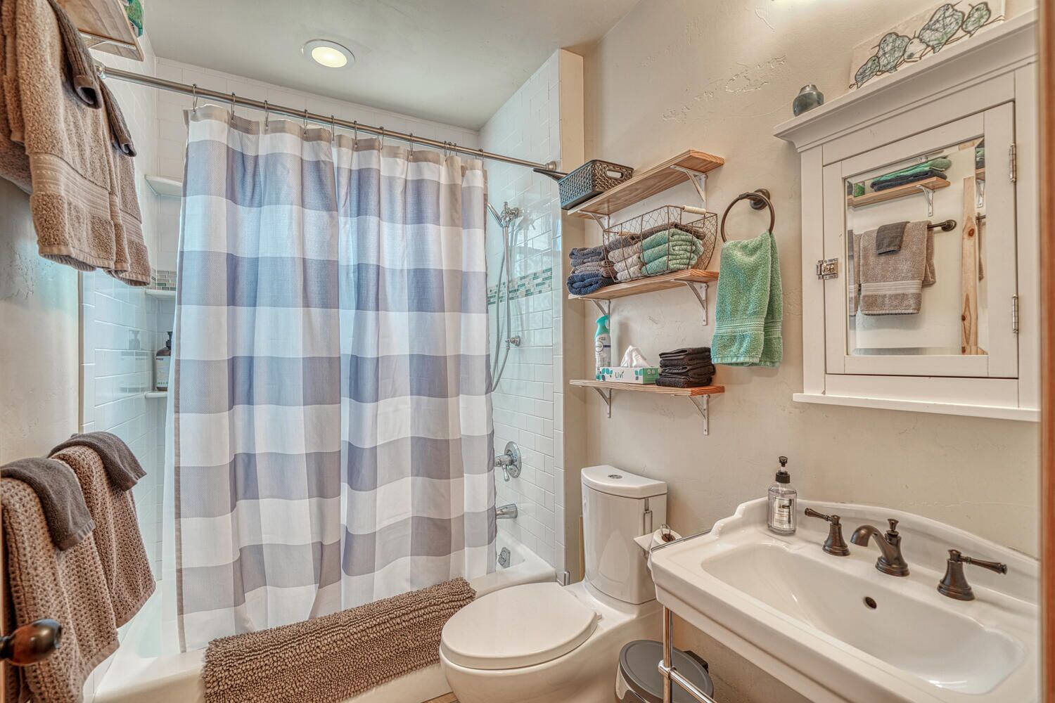 Une salle de bain équipée d’une douche, de toilettes, d’un lavabo et de porte-serviettes.