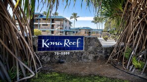 A sign for Kona Reef with a contact number.