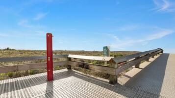 A wooden boardwalk with a red post and a green sign.