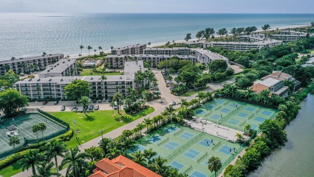A coastal hotel with multiple buildings, a tennis court, and a beach. - SUNDIAL D306 - Lovely Sundial Sanibel Condo. Short Walk to Beach (Sanibel)