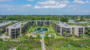 A modern hotel complex with multiple buildings, a central swimming pool, and surrounding greenery. - SUNDIAL D306 - Lovely Sundial Sanibel Condo. Short Walk to Beach (Sanibel)