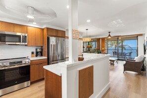 Una cocina moderna con electrodomésticos de acero inoxidable, armarios de madera y una isla grande.