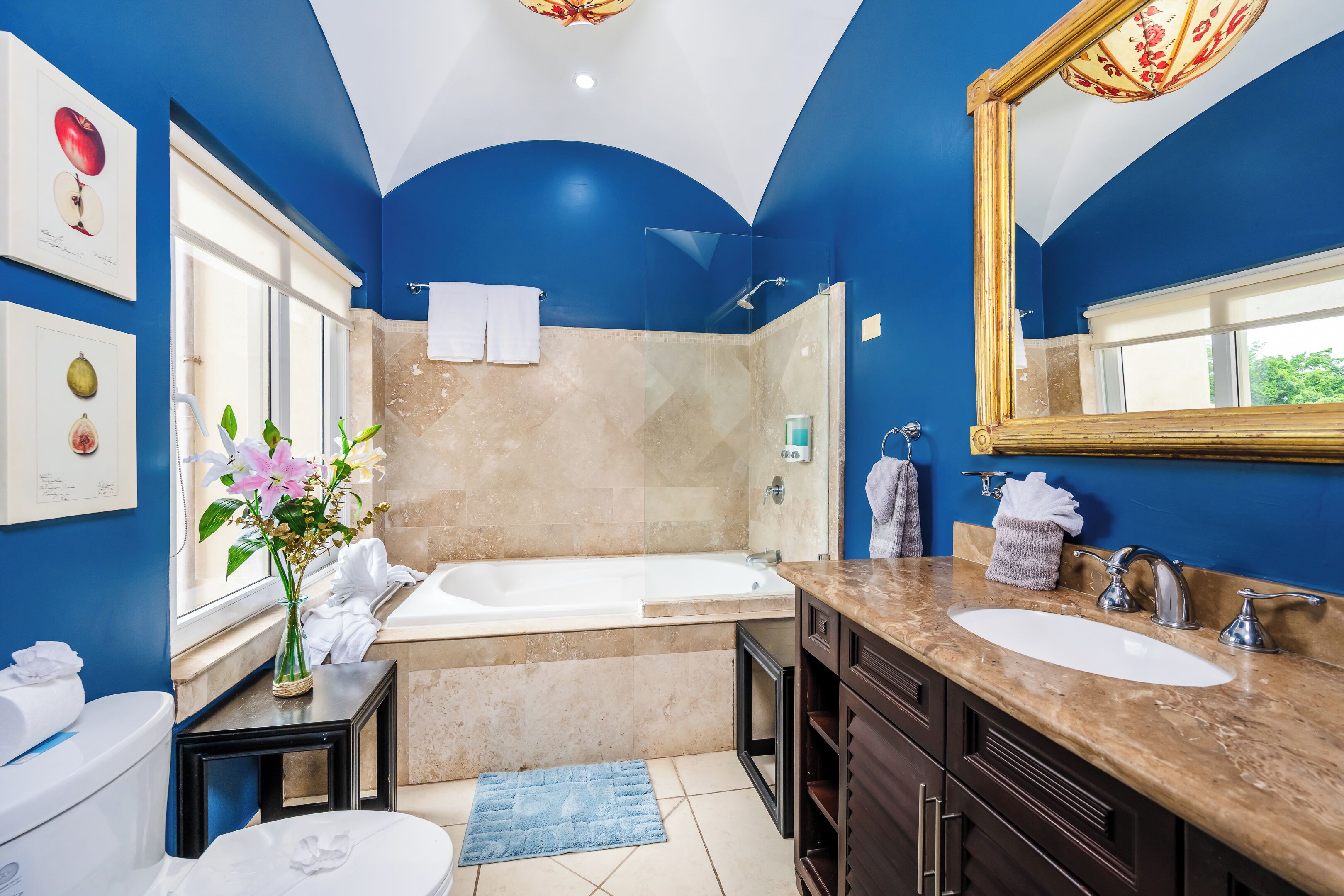 A bathroom with a bathtub, two sinks, and a large mirror.