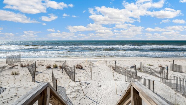 A beach with wooden structures and a clear view of the ocean. - Just Coastin: Great Gulf Views, Screened Porch, Pet Friendly (Cape San Blas)