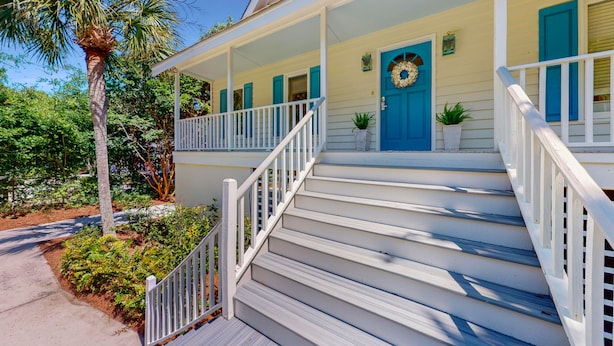 A two-story house with a porch, a blue door, and a staircase. - Hartnett Blvd 3502: 3  BR, 2  BA House in Isle of Palms, Sleeps 8 (Isle of Palms)