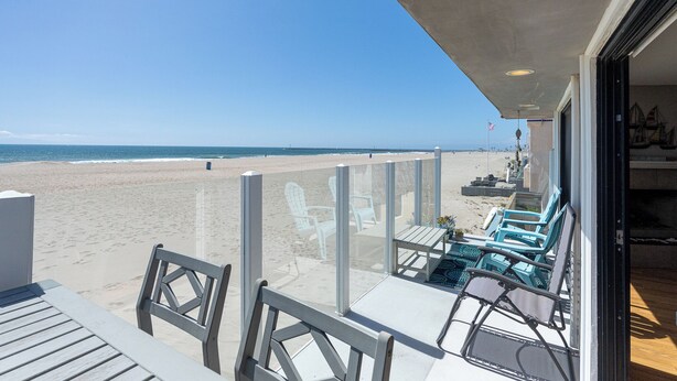 A beach view from a balcony with chairs and a table. - 1213O Local's Choice at Silverstrand (Oxnard)