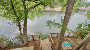A wooden staircase leading to a viewing platform with benches, overlooking a calm lake. - Riverside Roost- NB Guadalupe Riverfront + Easy River Access + Upper & Lower Decks + Minutes to Town (New Braunfels)