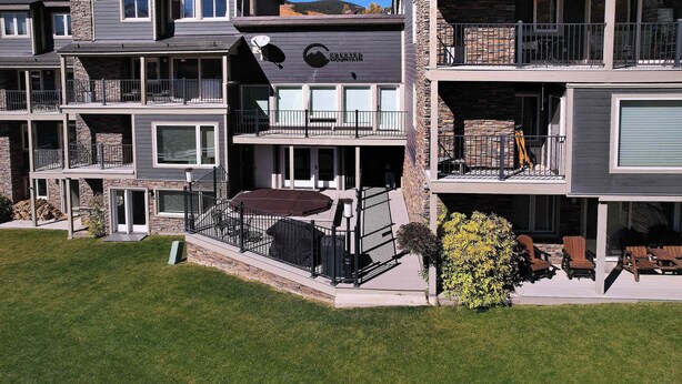 Un immeuble à plusieurs étages doté de balcons, d’un patio couvert et d’un espace extérieur aménagé pour s’asseoir.