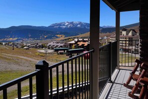 Un balcon offrant une vue sur une montagne, des bâtiments et un ciel dégagé.
