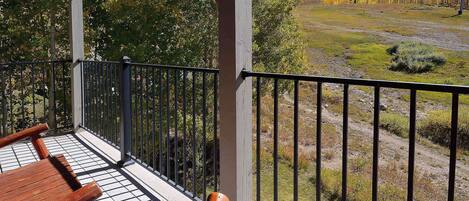 A balcony with a view of a mountainous landscape and autumn trees.