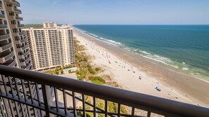 A high-rise hotel with a beach view, including a pool area and a sandy beach with people. - $150 activities - E-gift card when you book - Oceanfront Balcony | Gourmet Kitchen| M2203 (Myrtle Beach)
