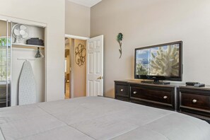 A bedroom with a bed, a TV, a dresser, and a closet with a fan and ironing board. - Simply Irresistible Superb 4 bedroom Home/ Community Pool/ North Phoenix/Scottsdale (Phoenix)