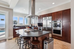 Enjoy cooking with a view of the ocean from this kitchen's large windows.