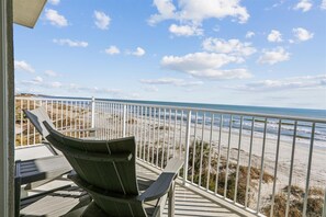 Enjoy the ocean view from this balcony with a sandy beach below.