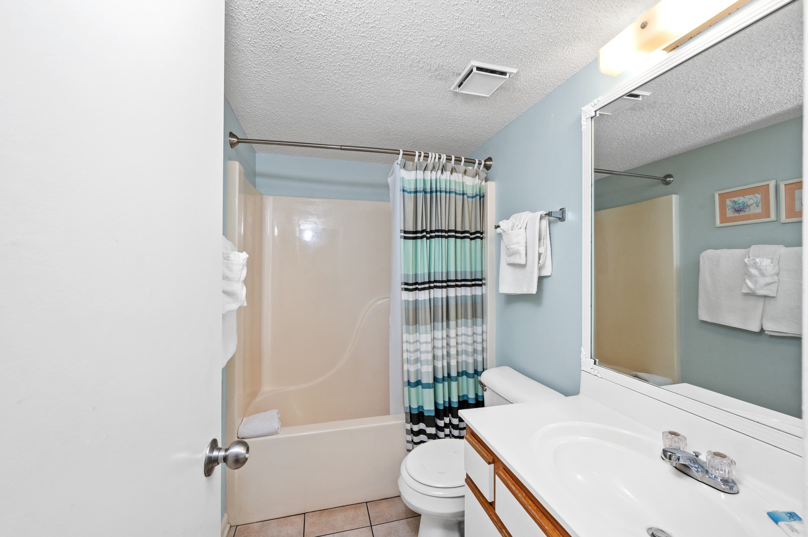 A bathroom with a bathtub, toilet, and sink.