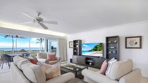 Ein Wohnzimmer mit Sofa, Couchtisch, Fernseher und Regalen.