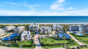 Ein Resort mit mehreren Gebäuden, einem Swimmingpool und Blick auf den Strand.