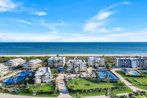 Un complexe hôtelier comprenant plusieurs bâtiments, une piscine et offrant une vue sur la plage.