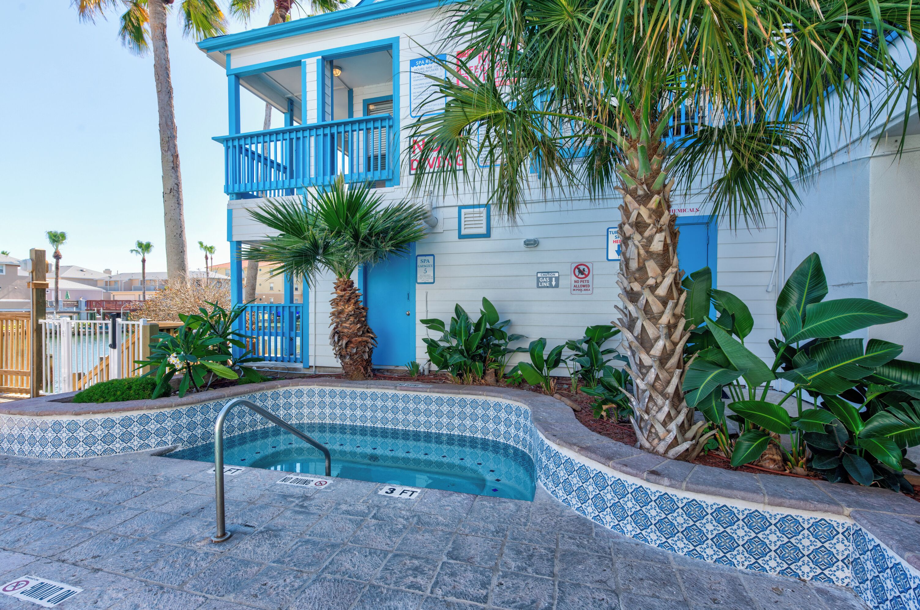 A two-story building with a blue exterior and a small pool area.