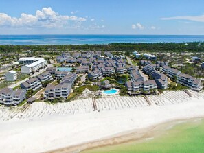 Un resort costero con varias edificaciones, una piscina y una playa.