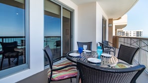 Enjoy a peaceful moment on this balcony with a table and chairs, overlooking the water and city views.