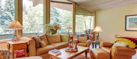 Relax in a spacious living room with a sofa, armchairs, and loveseat, perfect for unwinding or socializing.