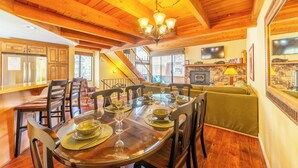 A wooden dining area with a large table set for six, surrounded by chairs.