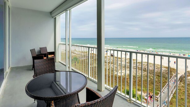 A balcony with wicker furniture and a view of the beach. - Lighthouse 410 by Liquid Life (Gulf Shores)